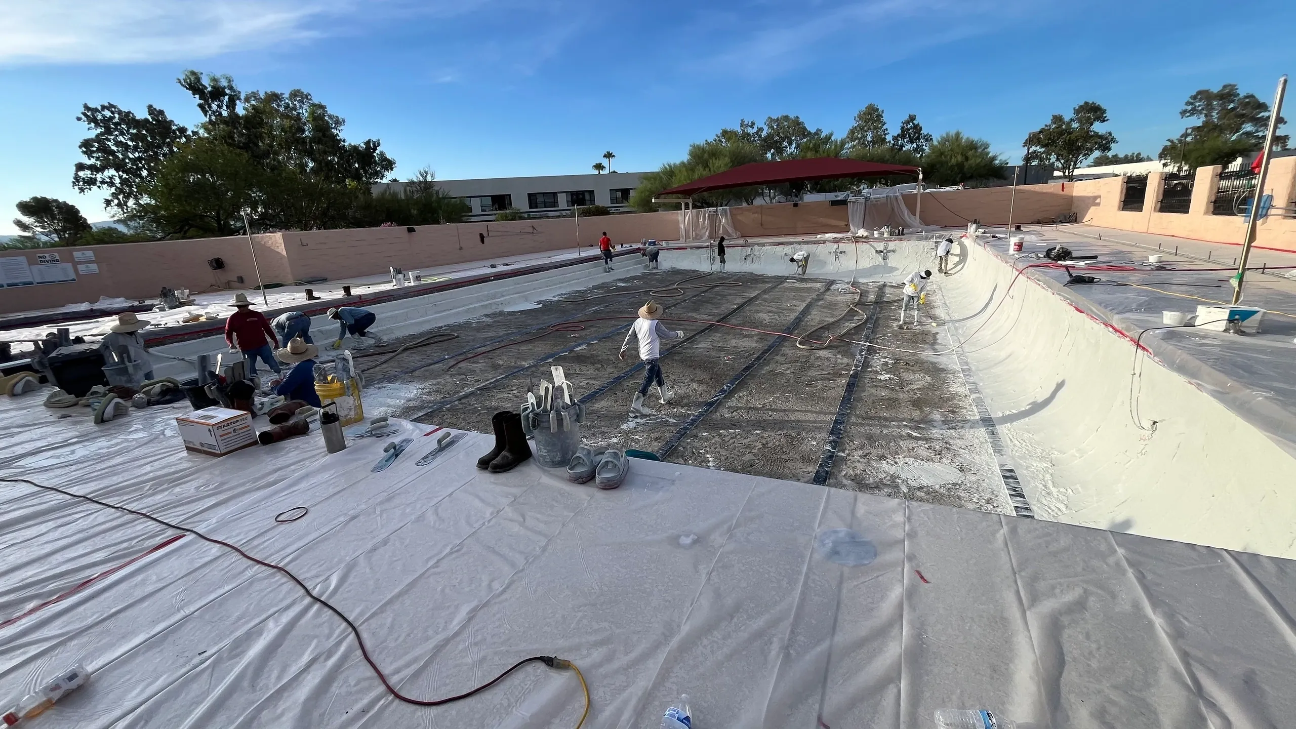 Workers installing pool membrane