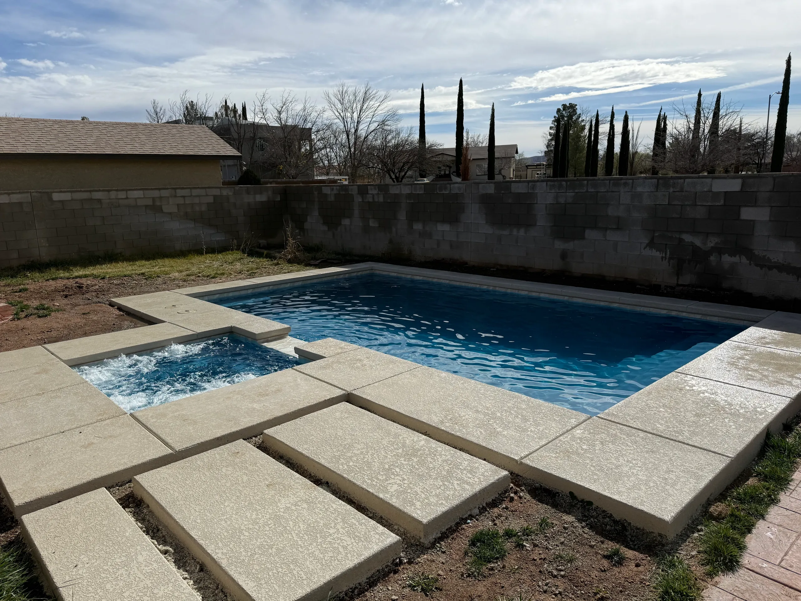 Elevated spa with spillover waterfall into pool